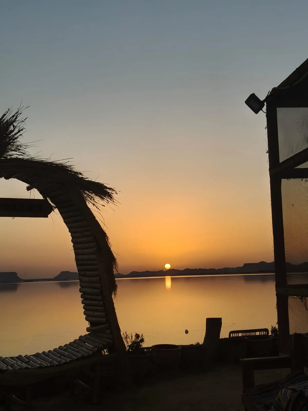 Siwa Oasis landscape at golden hour with palm groves and dunes — Breezy Island luxury resort, Egypt
